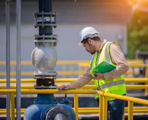 Engineer take water from wastewater treatment pond to check the quality of the water.