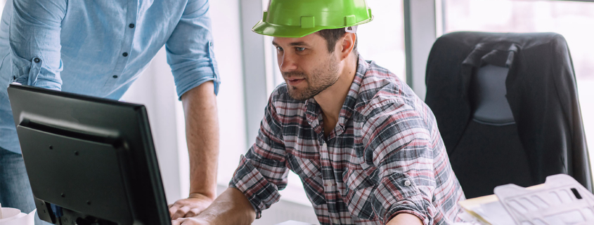 Construction engineer at a computer with a partner.